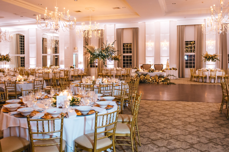 Elaborate ballroom with gold accents and chandeliers. 