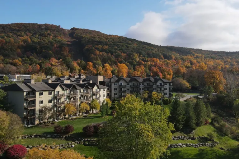 Wide view of Minerals Hotel in front of fall foliage.